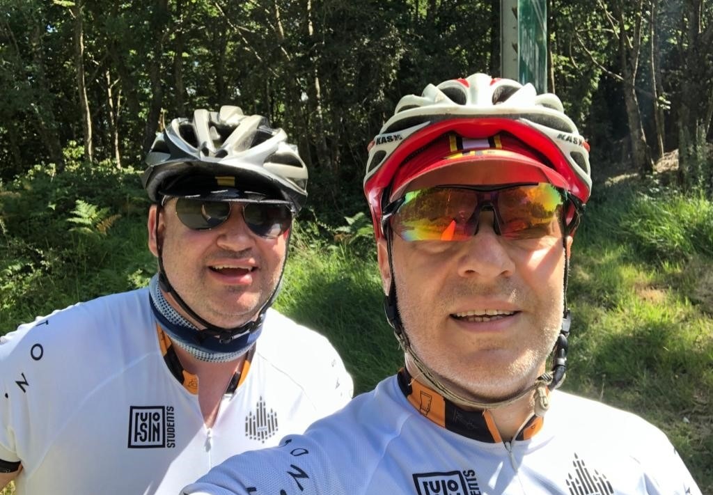 Two people riding a bicycle at a Kisharon Langdon challenge event